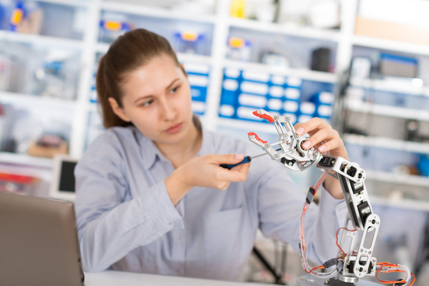 Schülerin arbeitet an Roboterarm